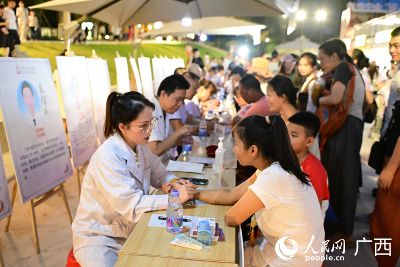 中医夜市中，市民排队体验诊疗服务。人民网 雷琦竣摄